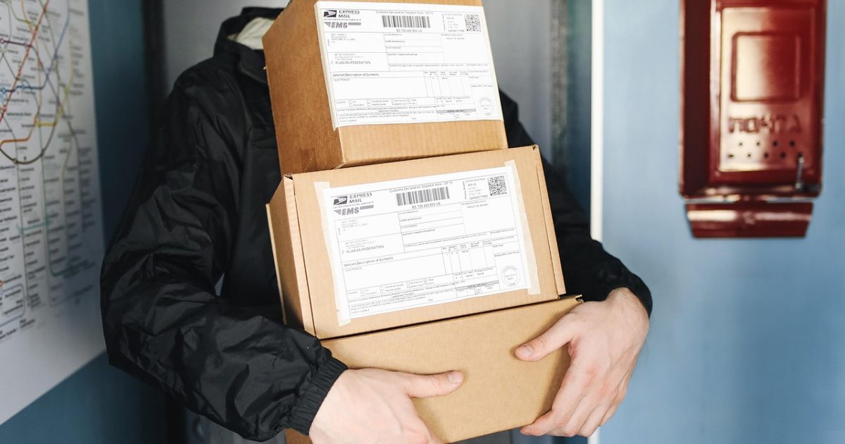 Kargo görevlisi elinde paketlerle teslimat için hazırlanıyor.